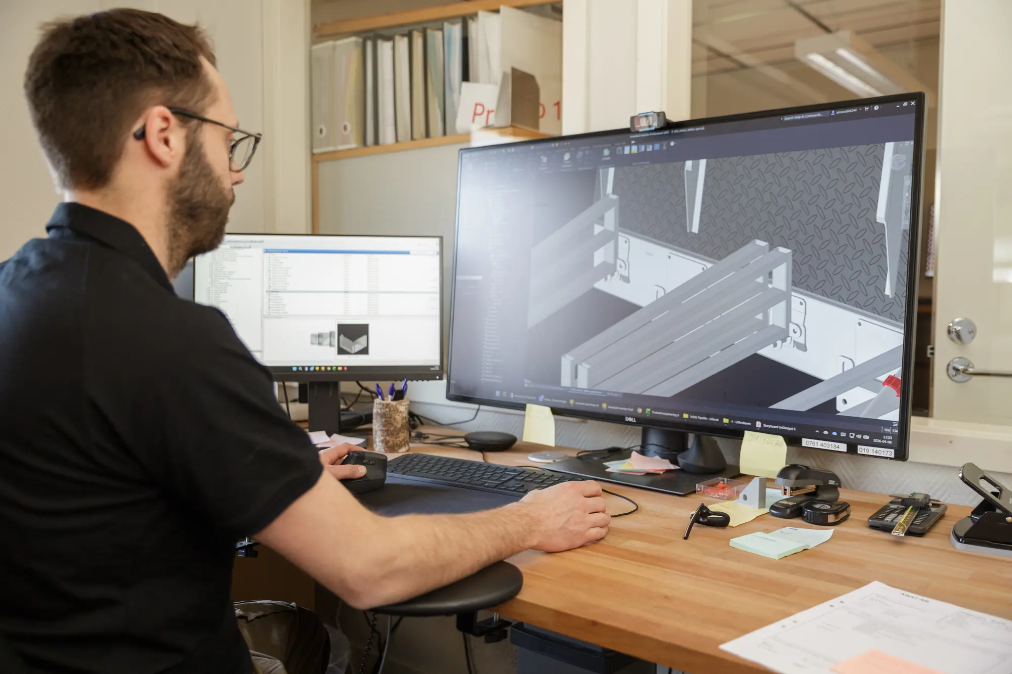 Konstruktör vid dator med 3D-modell av en lucka i CAD-program