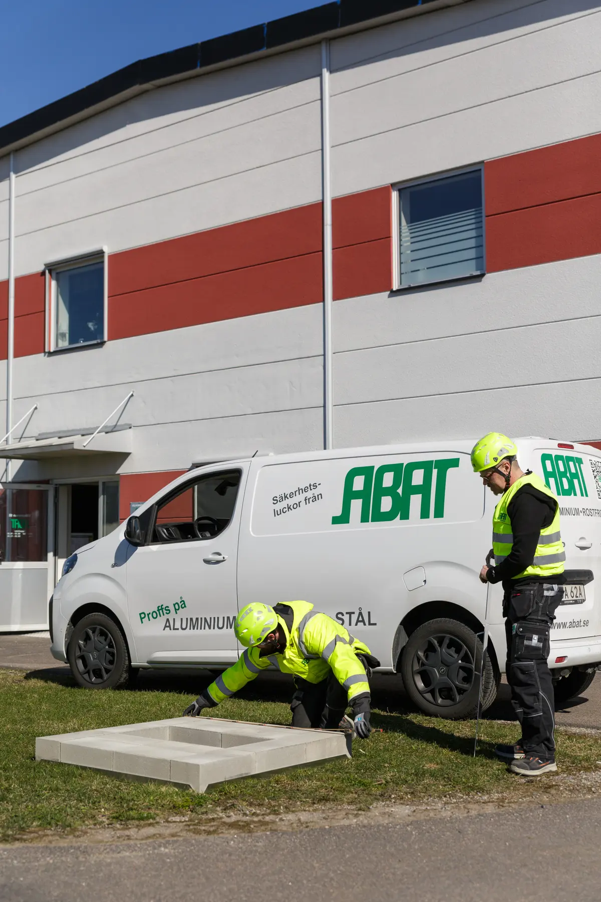 Montör mäter en luckram framför ABAT:s servicebil