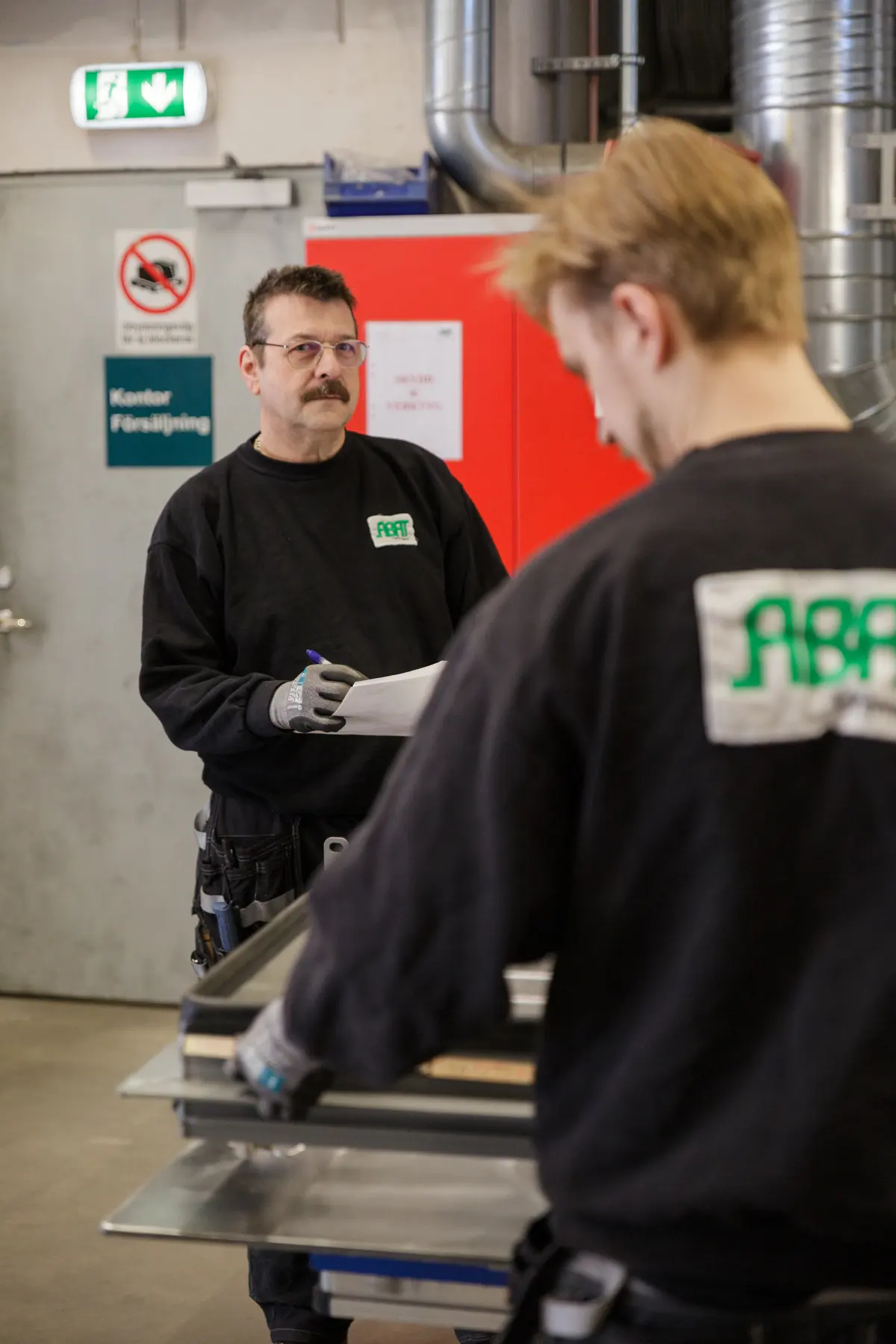 Två medarbetare i samtal i verkstaden